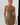 Woman wearing a strapless brown dress against a white wall.